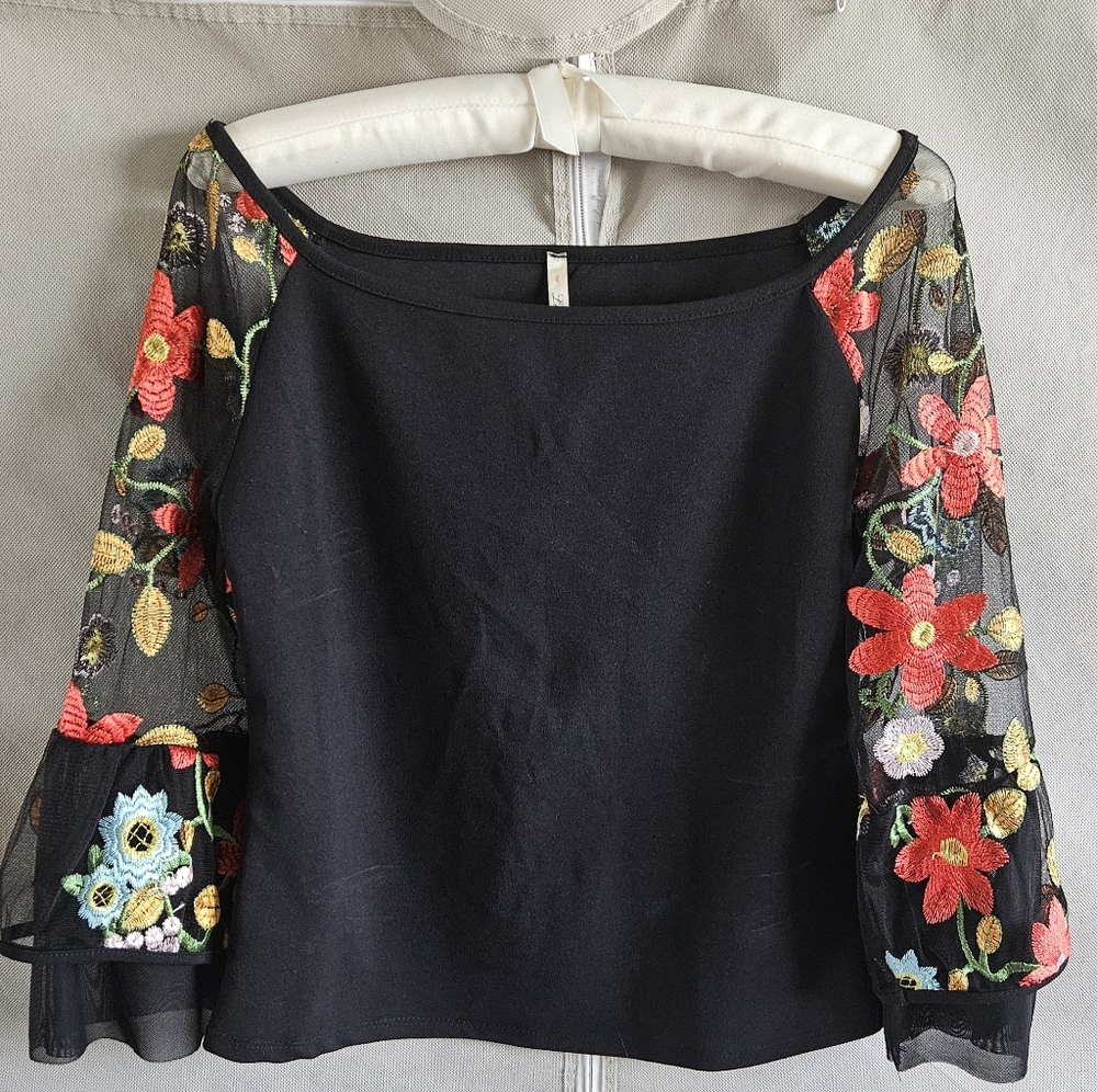 Elegant black cocktail blouse with unique semi-transparent sleeve with flowers.
